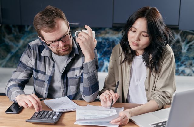 Couple calculant le budget d'installation d'une borne de recharge à domicile