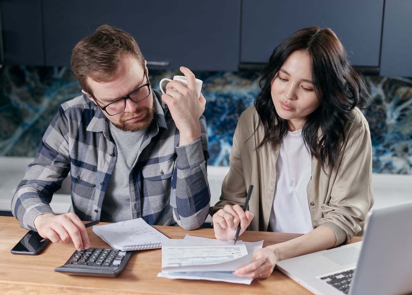 Couple calculant le budget d'installation d'une borne de recharge à domicile