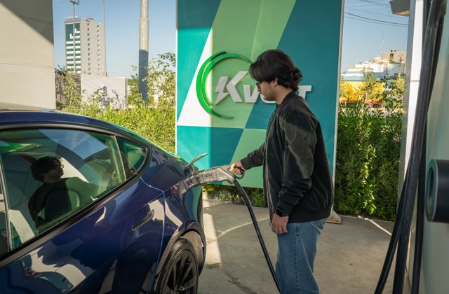 Automobiliste rechargeant sa voiture à une borne publique en itinérance