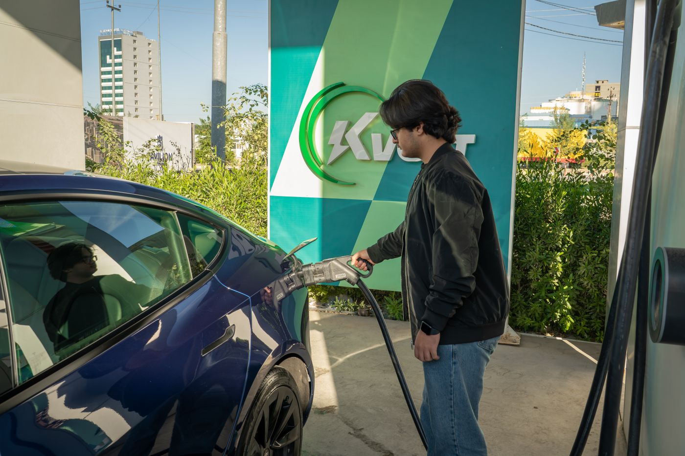 Automobiliste rechargeant sa voiture à une borne publique en itinérance