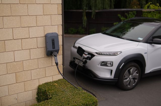 Voiture électrique en charge sur une borne murale à domicile