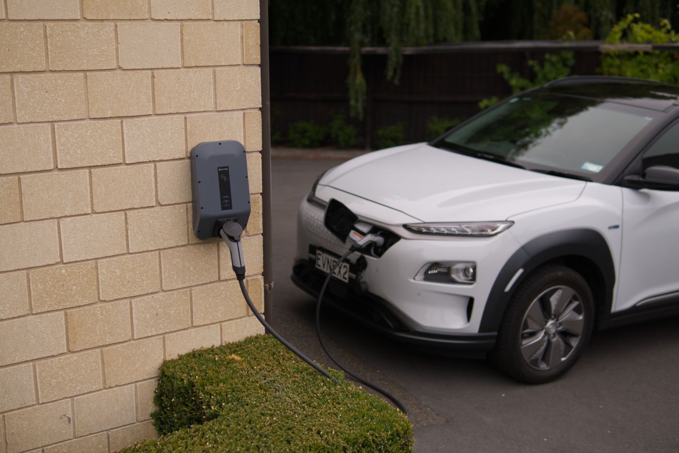 Voiture électrique en charge sur une borne murale à domicile
