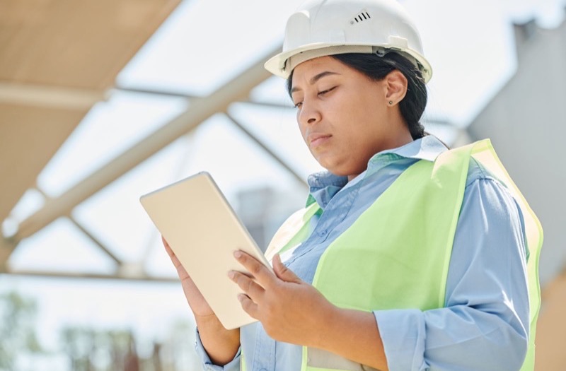Installateur IRVE consultant un logiciel de gestion de chantier sur tablette